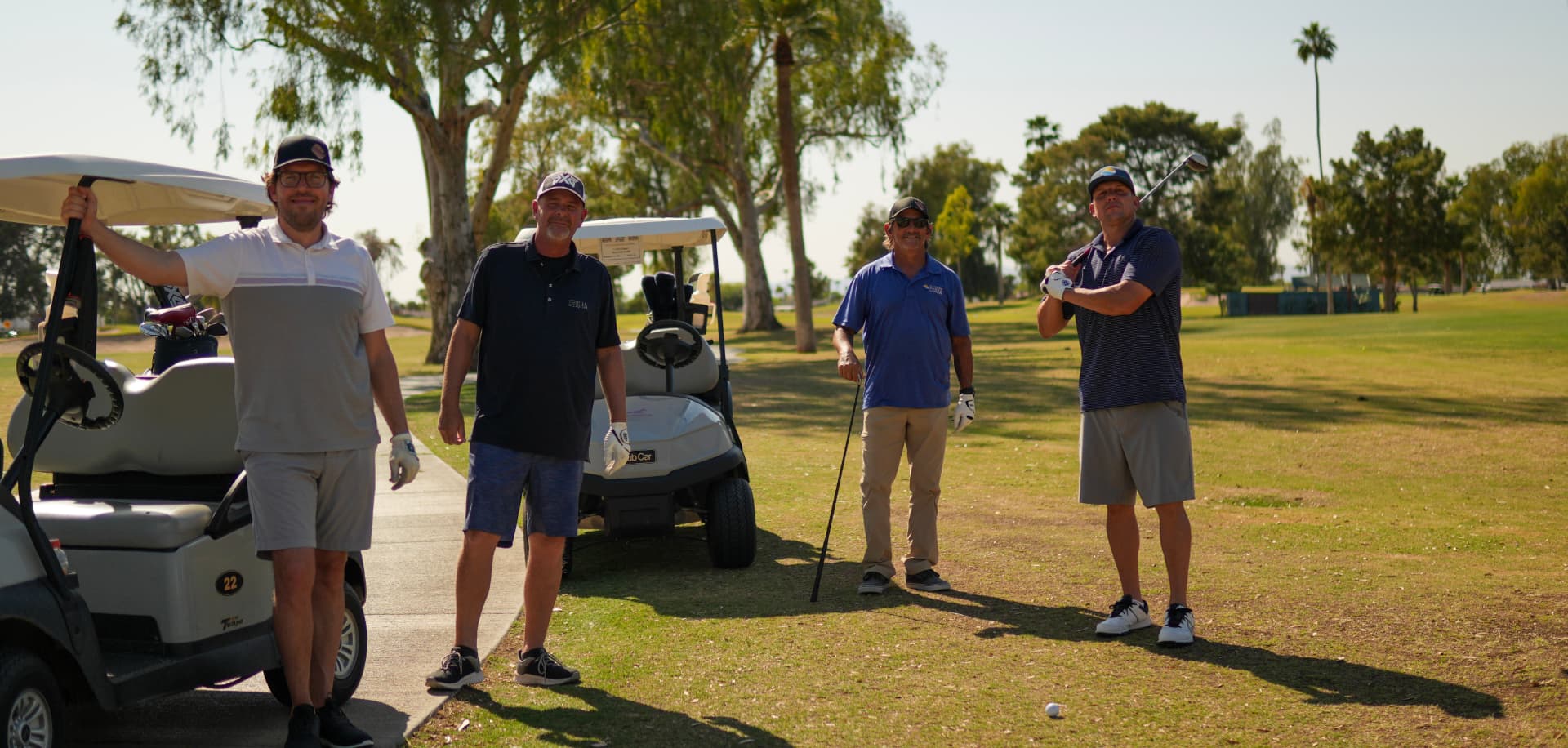 A foursome of SHA members with their carts and clubs on the fairway